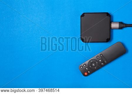 Tv Box And Remote Control For Ip Tv And Digital Video Content On A Blue Background