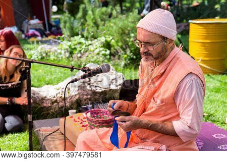 Moscow, Russia ,august 08, 2019: A Young Man With A Beard In A Knitted Hat And Glasses With A Tibeta
