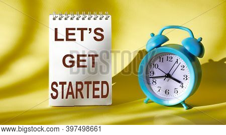 The Text Let's Started Is Written On A Calendar And A Yellow Background With An Alarm Clock Next To 