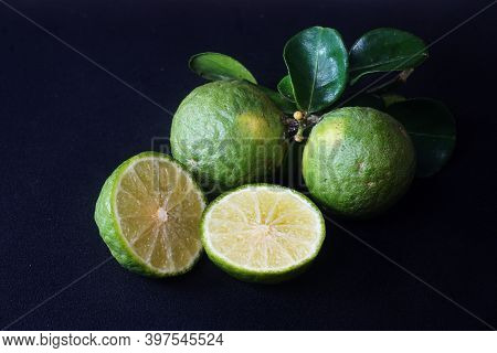 Kaffir Lime Or Citrus Hystrix. Some Are Whole, Some Have Been Sliced. Focus Selected, Black Backgrou