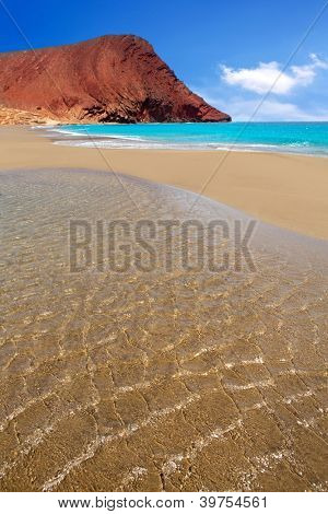 Stranden Playa de la Tejita turkis i Tenerife Kanariske øer med røde bjerg