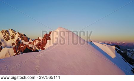 Epic Red Dawn On Top Of Snowy Mountains. Top View From A Drone. Huge Rocks Covered With Snow, The Le