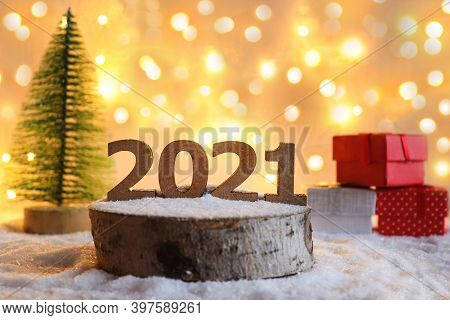 Beautiful New Year Greeting Card With Selective Focus. Numbers 2021 On Wooden Stand Against Festive 