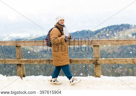 Happy Tourist Senior Woman With Backpack Standing On Observation Deck And Looking At Beautiful Mount
