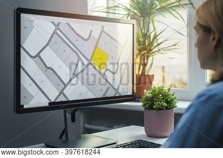 Woman Working With Digital Land Registry Database On Computer In Office
