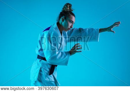 View From Side. Professional Female Judoist In White Judo Kimono Practicing And Training Isolated On
