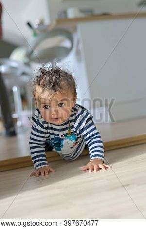 Cute 8-month-old baby girl crowling on all four