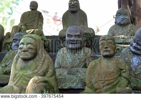 Figures Of Sitting Buddhist Monks Made Of Stone. Selective Focus.close Up.