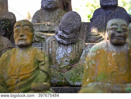 Figures Of Sitting Buddhist Monks Made Of Stone. Selective Focus.close Up.