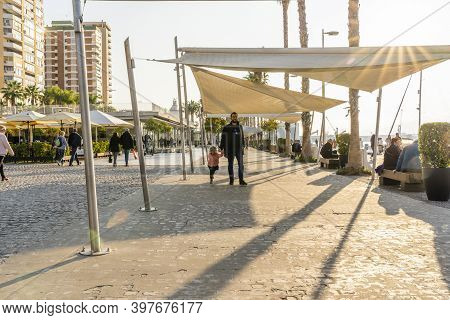 Malaga / Spain - May 18th, 2020: Father And Daughter Walking On Paseo Del Muelle Uno On Sunny Day