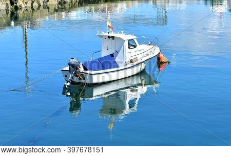 Portosin, Spain. June 19, 2020. Small Galician Fishing Boat With Water Reflection Moored In A Harbor