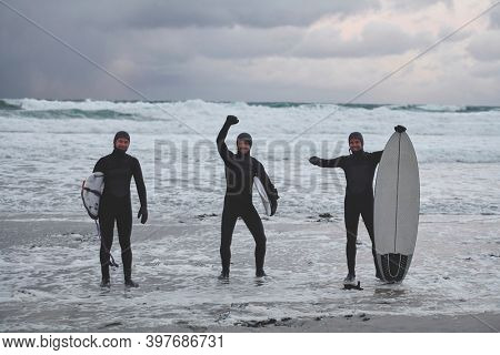 Arctic surfers going by beach after surfing