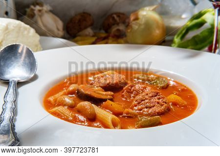 Creamy Italian Sausage Soup With Mozzarella Cheese Onions And Peppers Served With A Glass Of Red Win