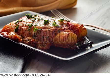 Italian American Baked Pasta Dish Stuffed Manicotti On Marble Kitchen Table