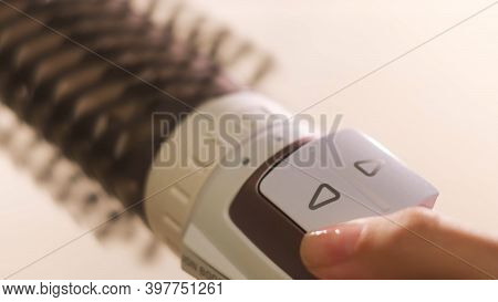 Close Up Of Hot Air Rotating Hair Styler In Female Hands. Concept. Woman Hands Showing The Work Of A