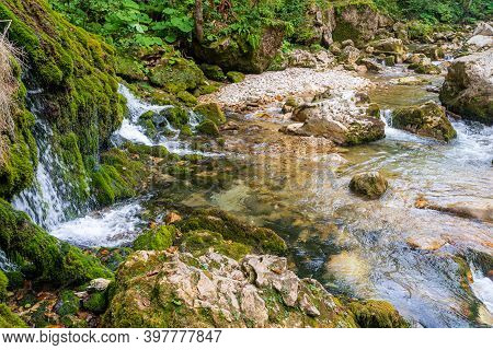 Ecology And Nature. The Source Of Clean Drinking Spring Water Among Stone Rocks And Moist Fresh Gree