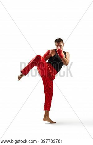 Athletic Man In Red Sports Bandages On His Hands Making Kick During Boxing Exercise, Isolated On Whi