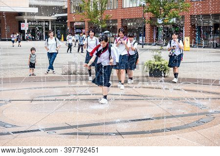 Oita, Kyushu, Japan August 04,2022: Young Japanese Schoolgirls Have Fun On The Way From School On Th