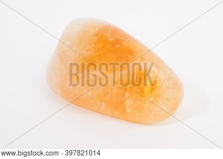 An Orange Calcite Gemstone, Shot Against A White Studio Background
