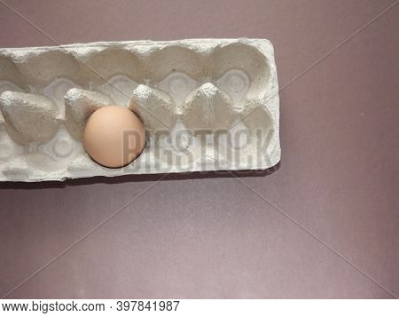 Beige Boiled Eggs In A Pot Of Water With An Egg Box On A Gray Background. High Quality Photo