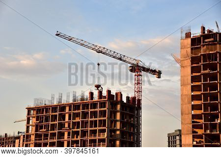 Preparing To Pour A Bucket Of Concrete Into Formwork.tower Crane Lifting Cement Bucket During Constr