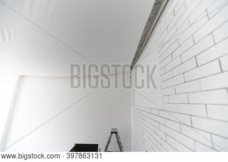 Stretch Ceiling. Workers Stretch The Suspended Ceiling In The Room. Ceiling Installation.