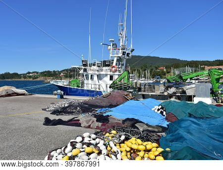 Portosin, Spain. July 3, 2020. Galician Fishing Vessel In A Harbor With Fishing Net At Famous Rias B