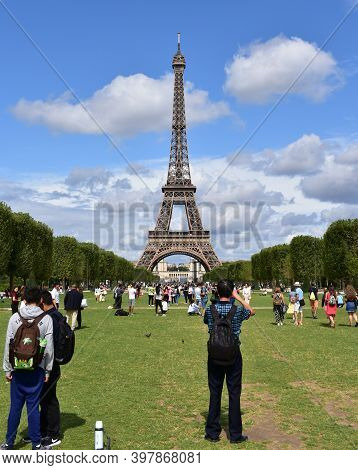 Paris, France. August 13, 2019.  Eiffel Tower With Tourists Having Fun And Taking Pictures From Cham