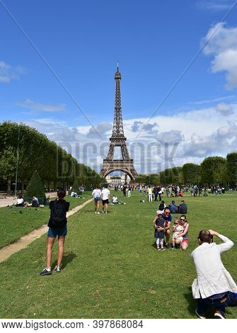 Paris, France. August 13, 2019.  Eiffel Tower With Tourists Having Fun And Taking Pictures From Cham