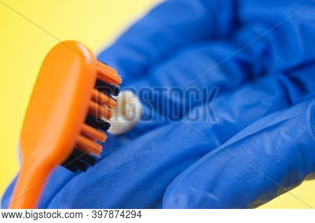 Tooth brush and deciduous milk child teeth on yellow background