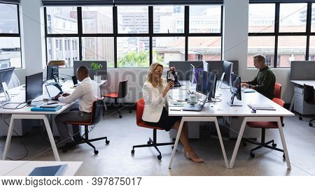 Caucasian woman working in creative office, putting virtual reality headset on. modern office business technology.