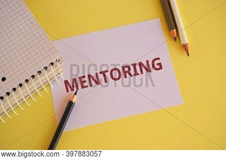 White Paper With Red Text Mentoring On Yellow Background. Word Writing Text Mentoring. Business Conc