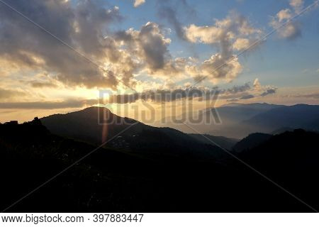 Blurred Silhouette Sunrise Over A Mountain Against Blue Sky White Clouds In The Morning With A Shado