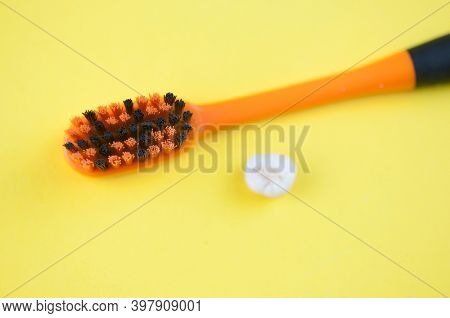 Tooth brush and deciduous milk child teeth on yellow background