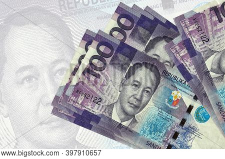 100 Philippine Piso Bills Lies In Stack On Background Of Big Semi-transparent Banknote. Abstract Pre
