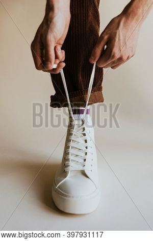 Man hands tying shoelaces white sneaker