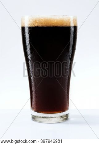 Dark beer with foam in a pint