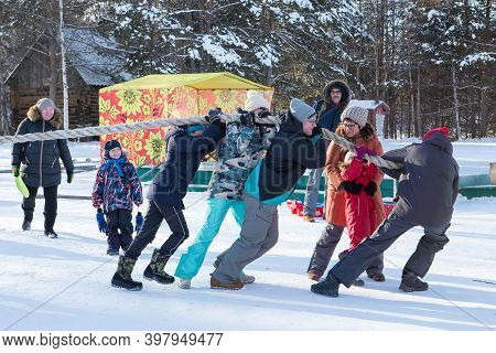 Irkutsk, Russia- 8 January 2019: Happy People Having Fun Playing Tug-of-war In Winter Park Of Museum