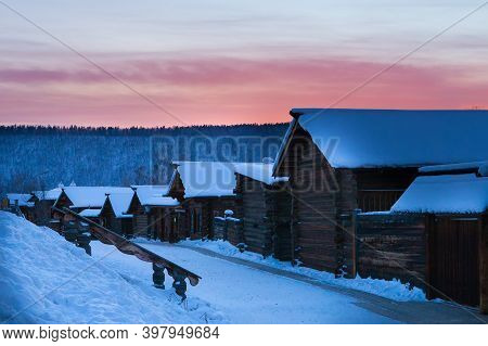 Irkutsk, Russia- 8 January 2019: Winter Landscape With Wooden Houses And Colorful Sky During Sunset 