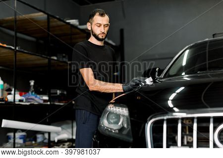 Young Man, Car Polish Service Worker Polishing Car Hood, Buffing And Polishing Vehicle With Nano Cer