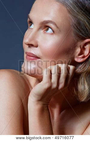 mooie veertig jaar oude vrouw met natuurlijke make-up en gezonde huidtextuur op blauw grijs studio bac