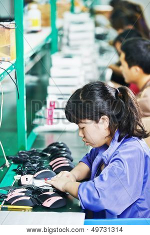 female chinese worker woman assembling production at line conveyor in china factory manufacturing