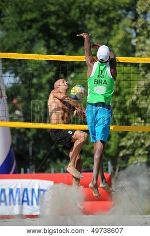 KAPOSVAR, HUNGARY - AUGUST 4: Balint Magyar (L) in action at a ROAK Viragfurdo Kupa beach volleyball competition, August 4, 2013 in Kaposvar, Hungary.