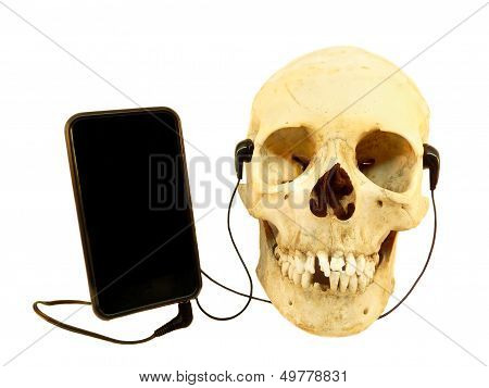 Human skull listening music with earphones on a mobile phone