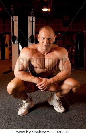 ยิ้ม Bodybuilder ในห้องฝึกอบรม