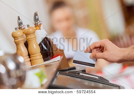 Close-up image of cashier male hands holding card