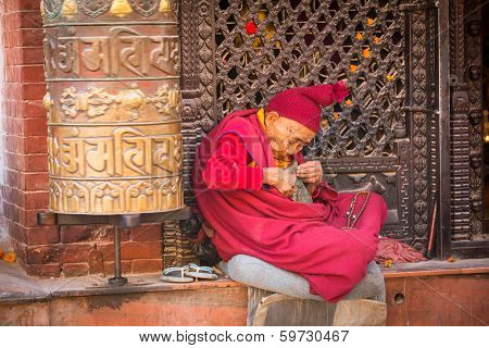 KATHMANDU, NEPAL - DEC 11, 2013: Portrait of unidentified Buddhist monk near stupa Boudhanath. Stupa is one of the largest in the world, of 1979 is a UNESCO World Heritage Site.