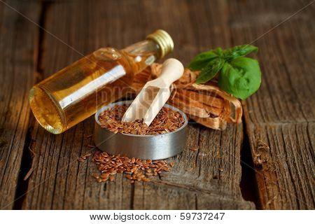 Dried linseed with macerated oil isolated on wooden table