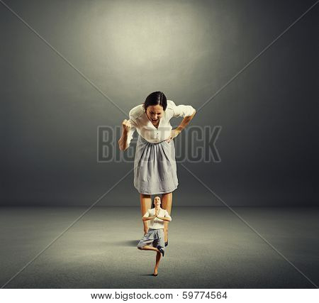 big woman screaming at small herself. concept photo of self reproach