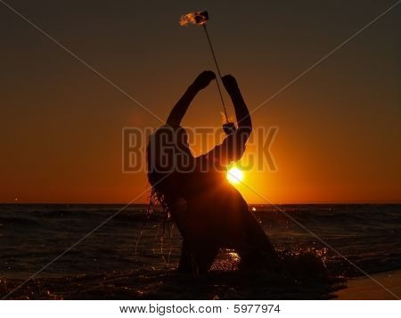 석양에 여성 불 마술사
